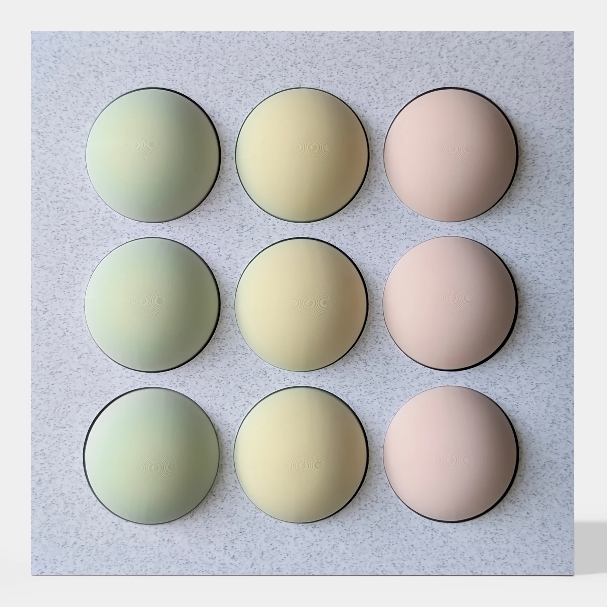 קופסה בהדפסת תלת מימד בצבע שיש אפור עם 9 כדורים מחולקים לצבעי ורוד, צהוב בהיר וירקרק