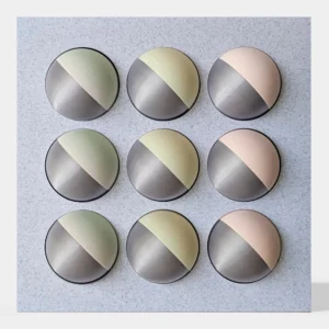 קופסה בהדפסת תלת מימד בצבע שיש אפור עם 9 כדורים מחולקים לצבעי כסף מנצנץ, ורוד, צהוב בהיר וירקרק