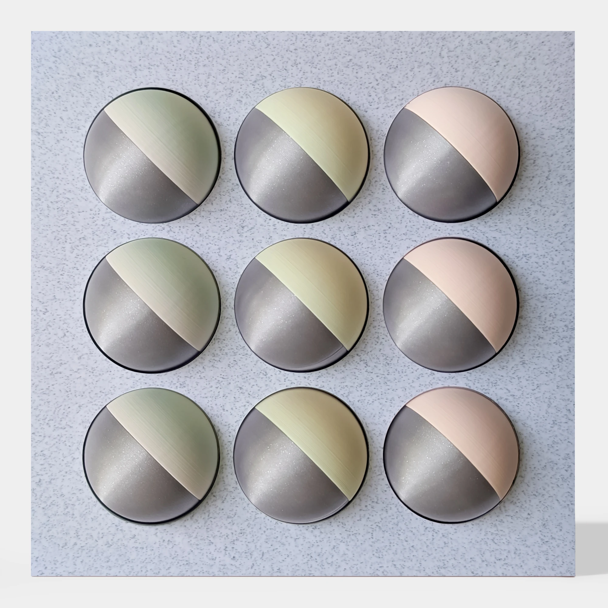 קופסה בהדפסת תלת מימד בצבע שיש אפור עם 9 כדורים מחולקים לצבעי כסף מנצנץ, ורוד, צהוב בהיר וירקרק