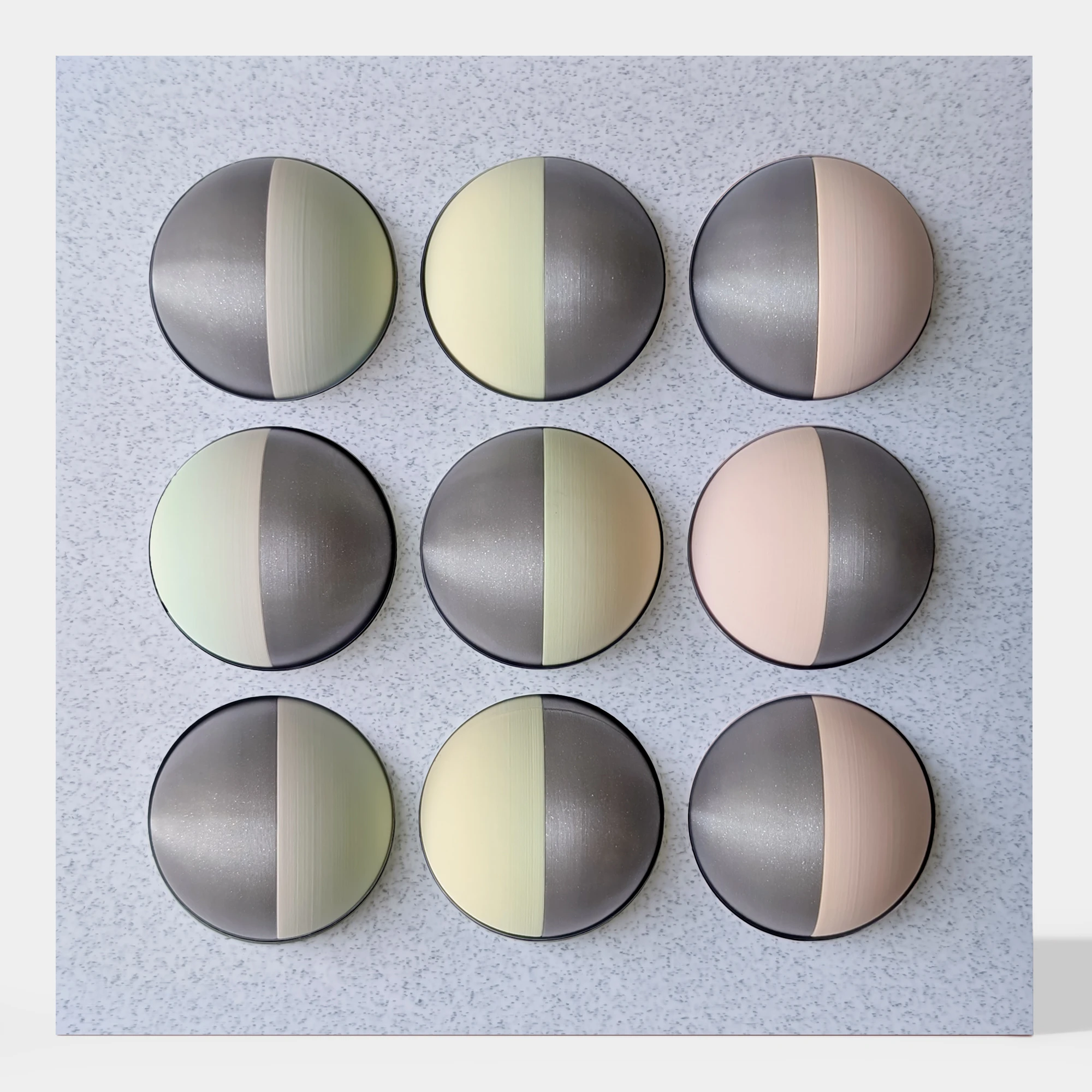 קופסה בהדפסת תלת מימד בצבע שיש אפור עם 9 כדורים מחולקים לצבעי כסף מנצנץ, ורוד, צהוב בהיר וירקרק